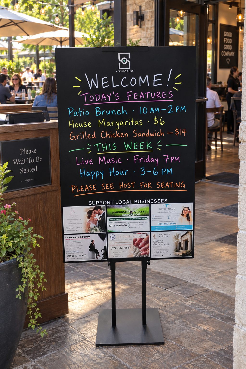A Side Door Hub board on a restaurant patio welcoming guests with today’s features, live music and happy hour, with featured local businesses below.